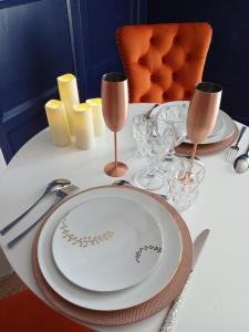 a table with a plate and wine glasses on it at Arthur et Eva - Lit King size - gare - centre - hopital in Abbeville +4 photos