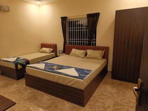 a bedroom with two beds and a window at PVR Grand Residency in Tiruvannāmalai