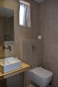 a bathroom with a white sink and a toilet at Red Rose Garden in Tsilivi +16 photos