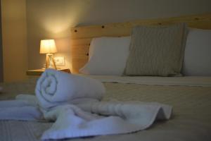 a pile of towels on a bed next to a lamp at Red Rose Garden in Tsilivi