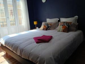 a white bed with pillows and a purple towel on it at Arthur et Eva - Lit King size - gare - centre - hopital in Abbeville