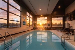 a swimming pool in a building with a sunset at Prestige Prince George Lodge in Prince George