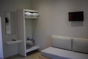 a living room with a couch and a tv at Red Rose Garden in Tsilivi