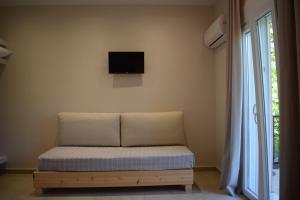 a couch in a room with a tv on the wall at Red Rose Garden in Tsilivi