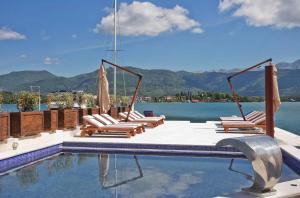 a swimming pool with lounge chairs and the water at Villa Regulus in Tivat