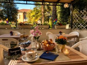 a table with a cup of coffee and a basket of fruit at Hotel Villa Pina in Senigallia