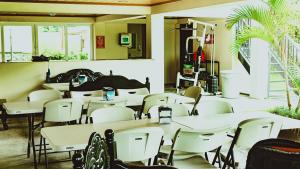 a room filled with tables and white chairs at Hotel Central Boquete in Boquete