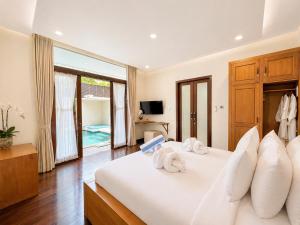 a bedroom with a white bed with towels on it at D'Avera Villa Canggu in Canggu +49 photos