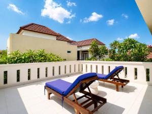 a patio with two lounge chairs and a fence at D'Avera Villa Canggu in Canggu