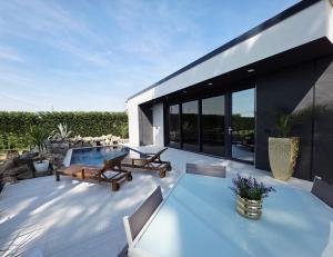 a patio with a table and chairs and a pool at The K Noir Private Pool Luxury Suite in Civé