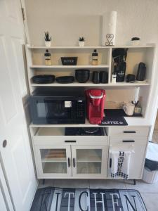 a kitchen with white shelves and a microwave at Comfy hideaway in Hollywood +14 photos