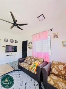 a living room with a couch and a ceiling fan at Teratak 93 in Karak
