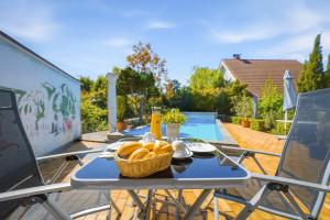 a picnic table with a basket of bread on a patio at Pension Haus Elmar in Rösrath