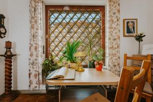 a room with a table and a window with plants at Pension Haus Elmar in Rösrath