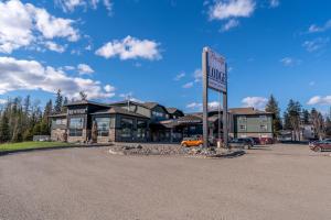 a building with a sign in front of a parking lot at Prestige Prince George Lodge in Prince George