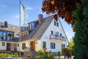 a white house with a gray roof at Pension Haus Elmar in Rösrath