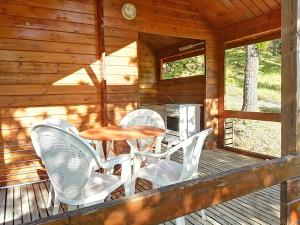 a porch of a cabin with a table and chairs at Saut du moine in Simiane-la-Rotonde