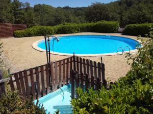 a swimming pool with a wooden fence around it at Saut du moine in Simiane-la-Rotonde