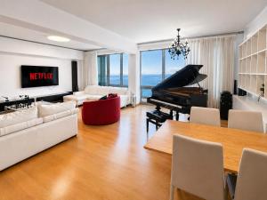 a living room with a piano and a table at Premium Seafront Suite in Thessaloniki