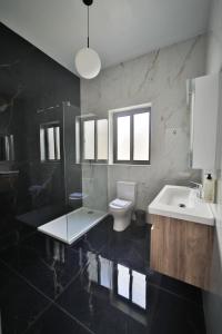 a bathroom with a toilet and a sink and a mirror at Hot Tub With View, Stylish 3BR, Heart of Ghajnsielem in Għajnsielem +87 photos