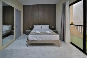 a bedroom with a large bed with towels on it at Hot Tub With View, Stylish 3BR, Heart of Ghajnsielem in Għajnsielem