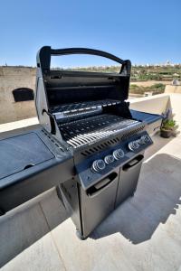 a grill sitting on top of a roof at Hot Tub With View, Stylish 3BR, Heart of Ghajnsielem in Għajnsielem