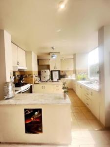a large kitchen with white cabinets and a counter top at Subvolcanic Point in Arequipa