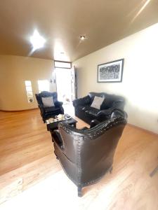 a living room with a leather couch and a table at Subvolcanic Point in Arequipa
