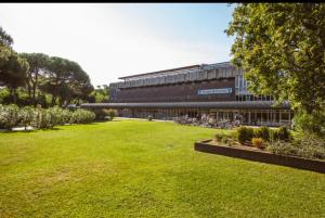 a large building with a green lawn in front of it at Pernottamento Madonna del Pino Cervia in Cervia