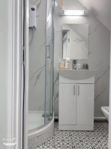 a white bathroom with a shower and a sink at Cove Guest Accommodation in Kinvara