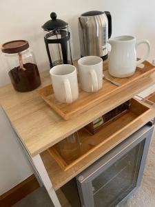 a table with three cups and a coffee maker on it at The Silver Suite at Manor Farm in Edenbridge +12 photos