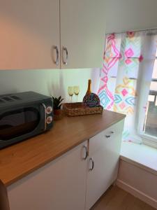 a kitchen counter with a microwave and two glasses of wine at Well St Apartment in Moffat +6 photos