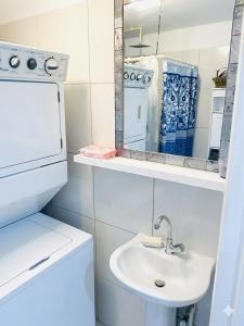 a white bathroom with a sink and a mirror at Studio Bella in Philipsburg +22 photos
