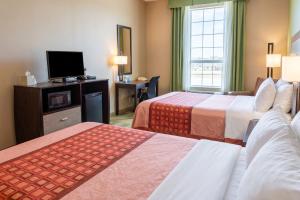 a hotel room with two beds and a flat screen tv at Cotulla Express Inn in Cotulla +20 photos