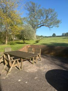 a picnic table and two benches in a park at The Silver Suite at Manor Farm in Edenbridge