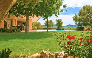 a house with a yard with red flowers at Los Arcos in Felanitx