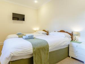 two twin beds in a bedroom with a tv at 2 Bed in Beaworthy oc-77555 in Black Torrington