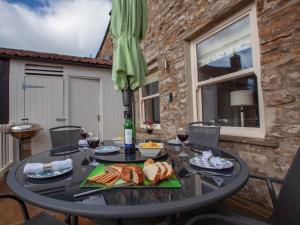 a table with food and wine glasses and an umbrella at 2 Bed in Richmond oc-74284 in Reeth