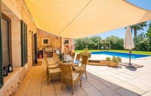 a patio with a table and chairs and an umbrella at Kiana in Santa Eugenia