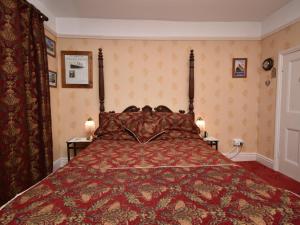 a bedroom with a bed with a red comforter at 1 Bed in Goodwick oc-fb274 in Goodwick