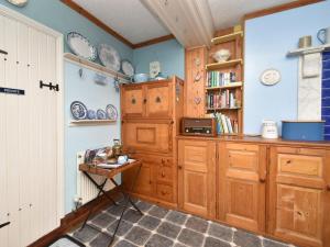 a kitchen with wooden cabinets and a table at 1 Bed in Goodwick oc-fb274 in Goodwick +9 photos