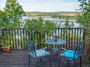 a table and chairs on a deck with a view of a lake at 1 Bed in Goodwick oc-fb274 in Goodwick