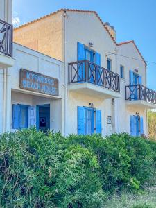 a beach house with blue doors and a sign at Kyparissis Beach house 1 in Lésvos
