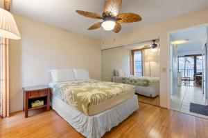 a bedroom with two beds and a ceiling fan at Maalaea Banyans Oceanfront in Wailuku +53 photos