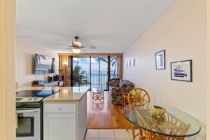 a kitchen and dining room with a glass table at Maalaea Banyans Oceanfront in Wailuku