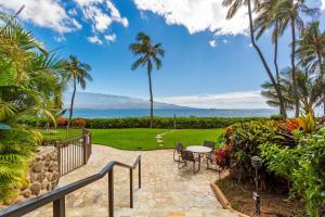a patio with a table and chairs and the ocean at Maalaea Banyans Oceanfront in Wailuku