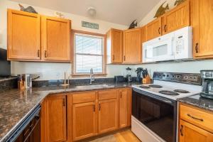 a kitchen with wooden cabinets and a stove top oven at Carolina Kai, Kitty Hawk MP 3, 275 Yds to Beach, Ocean View, Pool, Hot Tub, Flex Stays in Kitty Hawk +39 photos