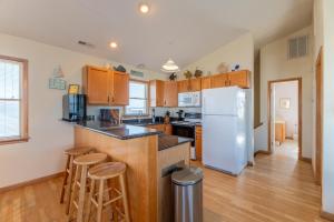 a kitchen with wooden cabinets and a white refrigerator at Carolina Kai, Kitty Hawk MP 3, 275 Yds to Beach, Ocean View, Pool, Hot Tub, Flex Stays in Kitty Hawk