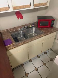 a kitchen with a sink and a red microwave at Joe's Studio in San Juan