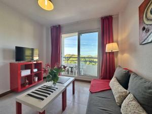 a living room with a couch and a table and a window at Duplex primera linea La Arena 4607 in Arnuero